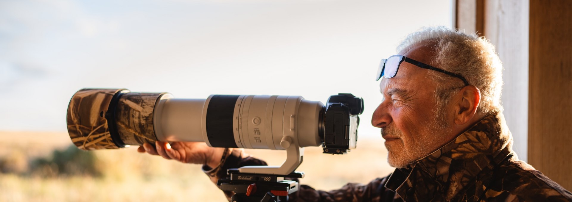 An experienced photographer with a telephoto lens observes the wildlife in the Vorpommersche Boddenlandschaft National Park.