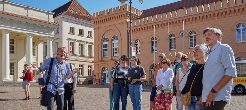 City guide with a group of guests at the Schwerin market in front of the town hall., © Oliver Borchert