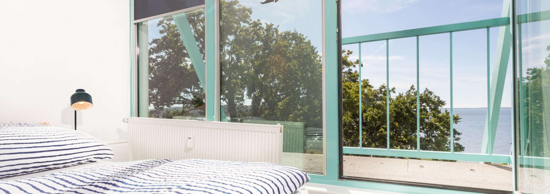 Bright bedroom with a view of the Bodden, perfect for relaxing after a productive day at work., © Project Bay