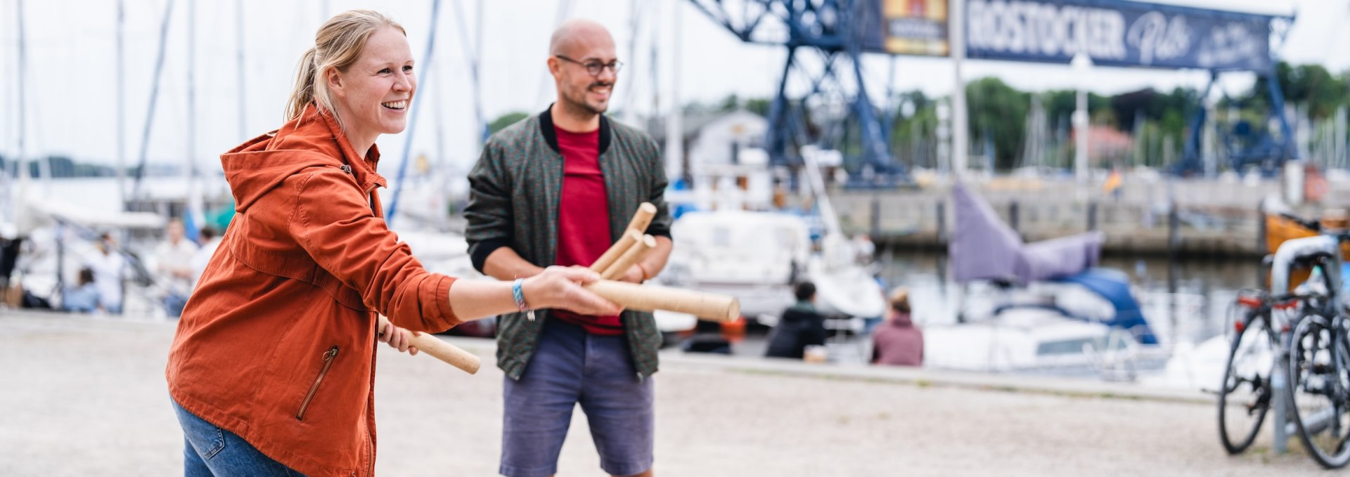 In summer, people meet up on the Rostock quayside to play Viking chess. Claudi and Tom try to knock over the opposing team's blocks with the wooden sticks.