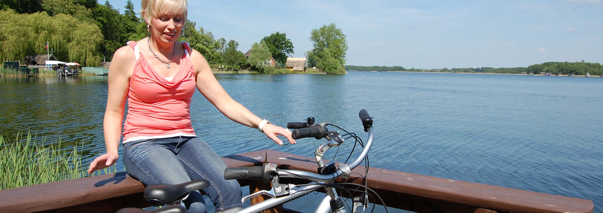 A cyclist sits on railings by the lake., © Ralf Tetmeyer, radreisen-mecklenburg