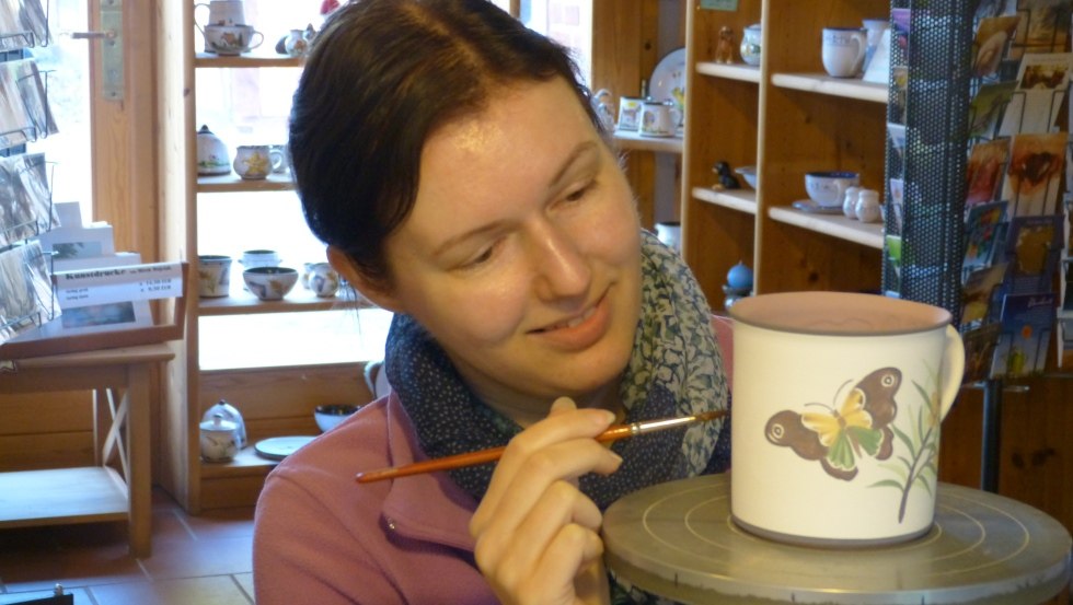 Looking over the shoulder of the painter Yvonne Bräunig while painting the ceramics, © Ummanz-Keramik/Schmorell