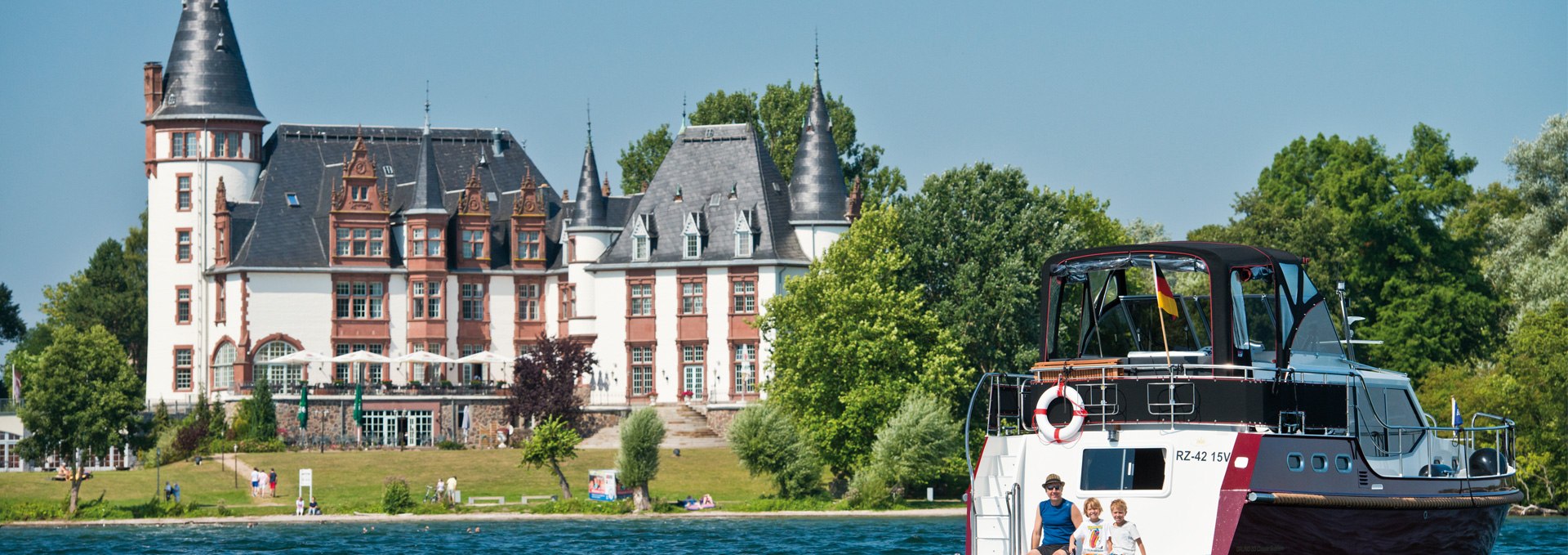 With the houseboat on the Müritz in front of the castle Klink, © Yachtcharter Schulz