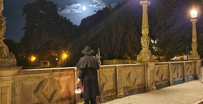 Night watchman on the bridge looking towards the castle at night., © Michael Kratt