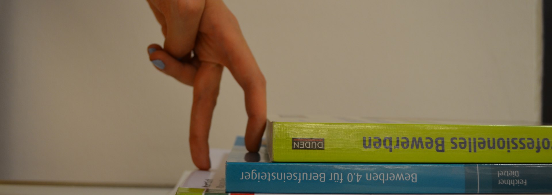 Two fingers climb a bookcase staircase, © Stadtbibliothek Stralsund