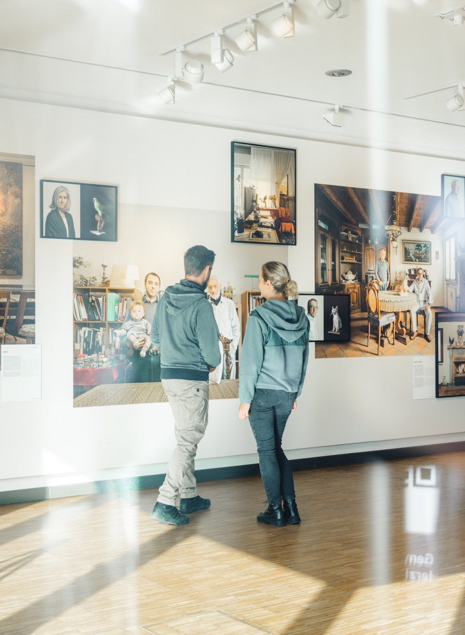 Two visitors look at photographs on a wall in the exhibition at the Max Hünten Haus in Zingst.