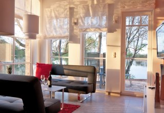 Living area of the vacation apartment osprey with large barn windows, © Andre Pretzel