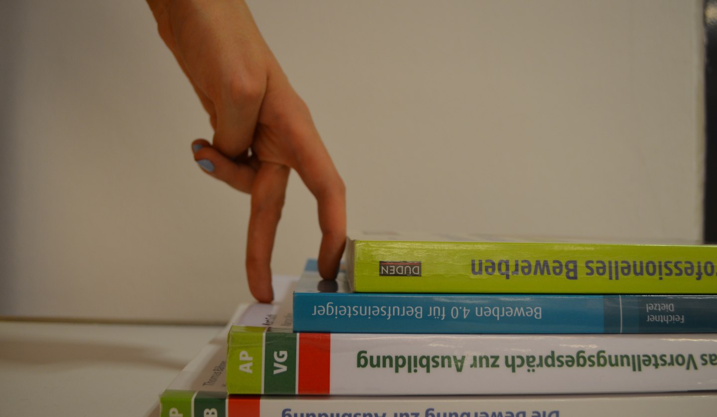 Two fingers climb a bookcase staircase, © Stadtbibliothek Stralsund