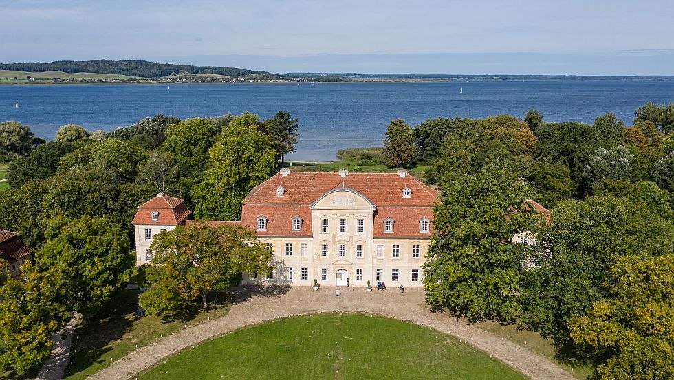 Aerial view of Kumerow castle, blue lake glistens in the background, © Tourismusverband Mecklenburgische Seenplatte/Tobias Kramer