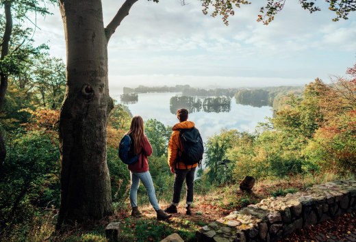 A couple looks down from the Reiherberg in Feldberg onto the Feldberger Haussee