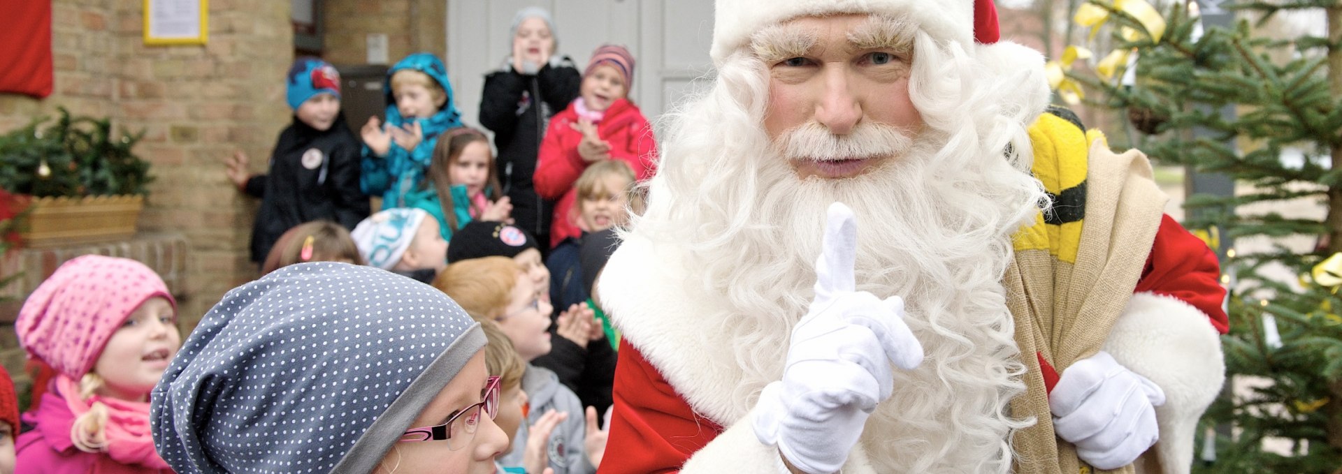 Santa Claus with children in front of Christmas post office, © Deutsche Post DHL Group