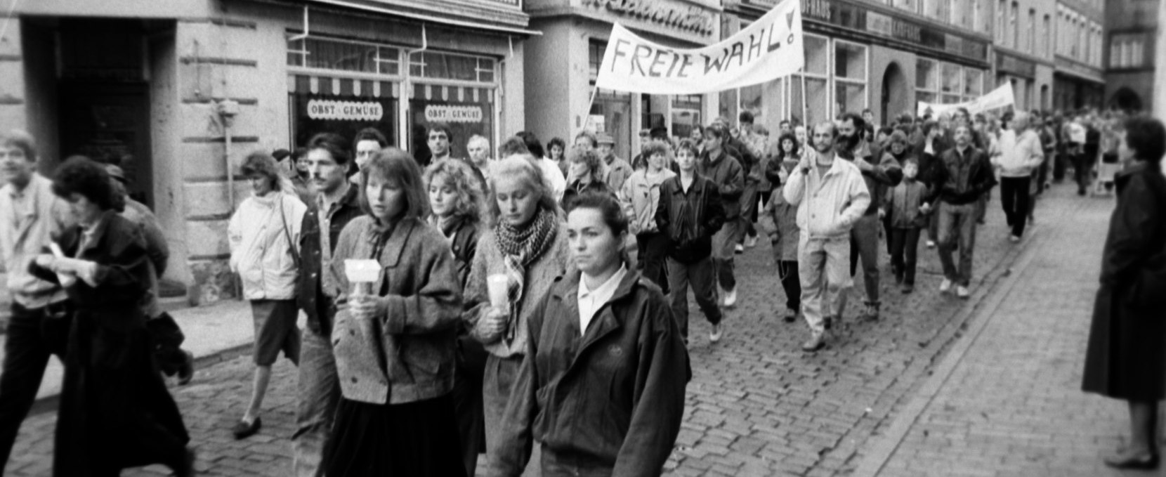 Demonstrators pass the former Parchimer Straße des Friedens, their banners calling for free elections., © Willy Voß