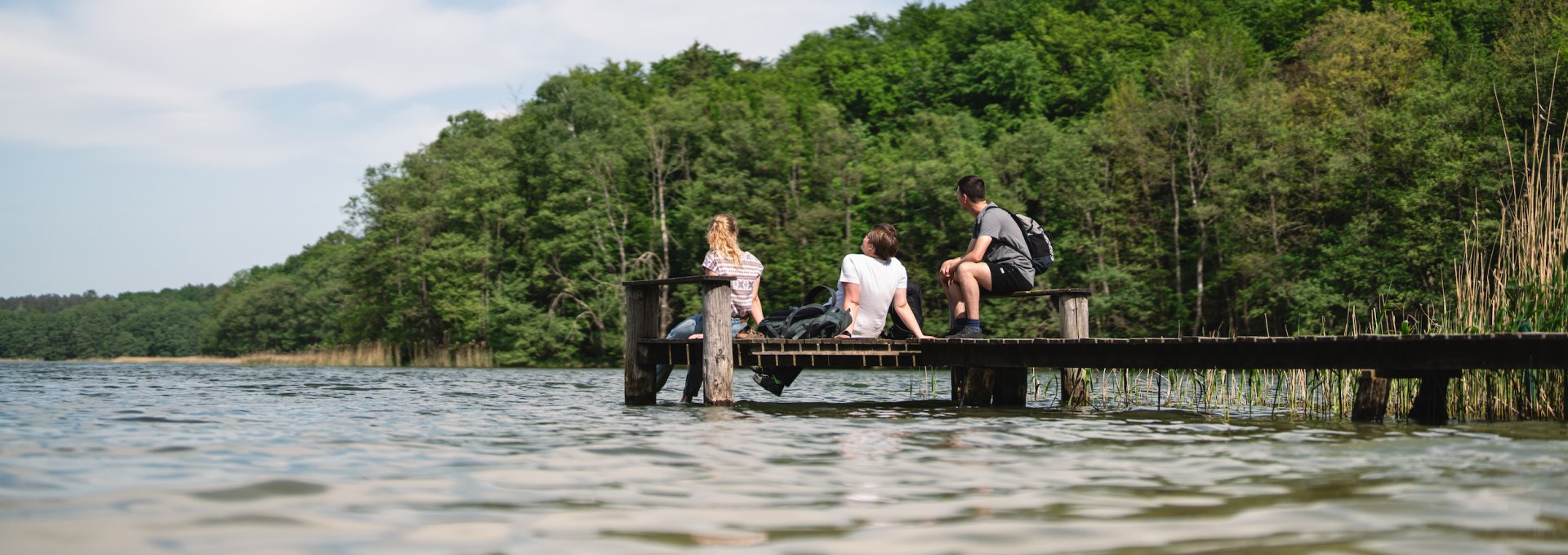 Fancy a break? It's best to stop at every corner and enjoy nature, just like these three friends here on the reedy shore of Lake Groß Labenz near Friedrichswalde., © TMV/Gross