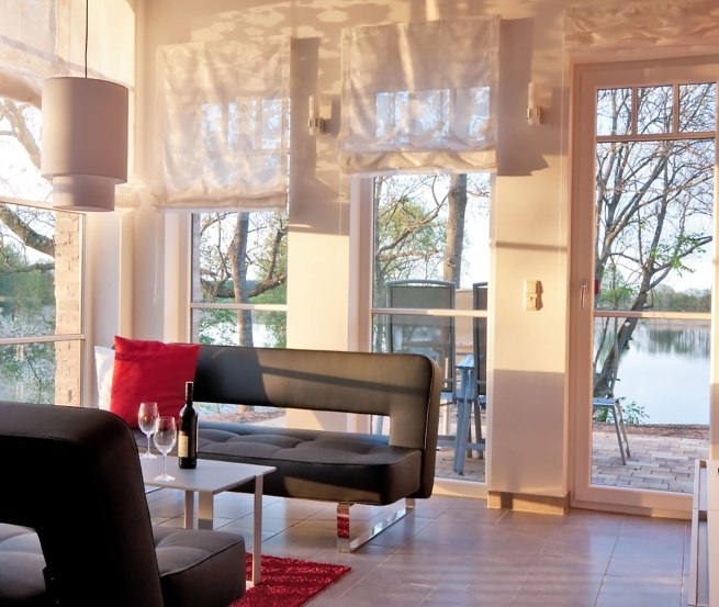 Living area of the vacation apartment osprey with large barn windows, © Andre Pretzel