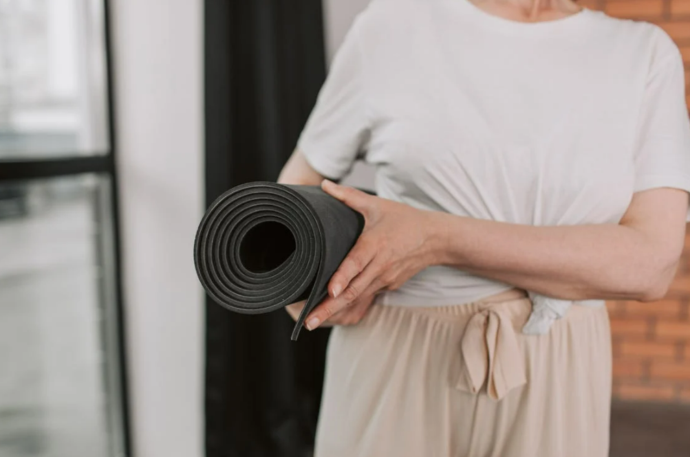 Woman with yoga mat, © MOVA PLACE - Yoga & Co. Studio