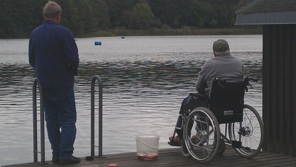 Holidaymaker in wheelchair gets assistance with fishing, © Birkenzweig e. V.