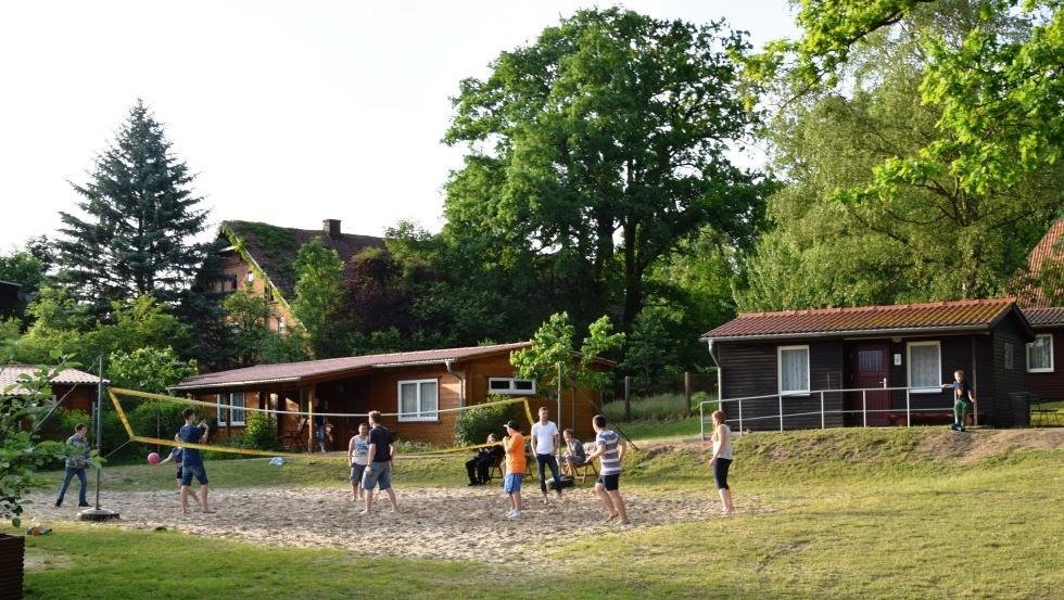 Volleyball court with log houses in background, © Zebef e.V.