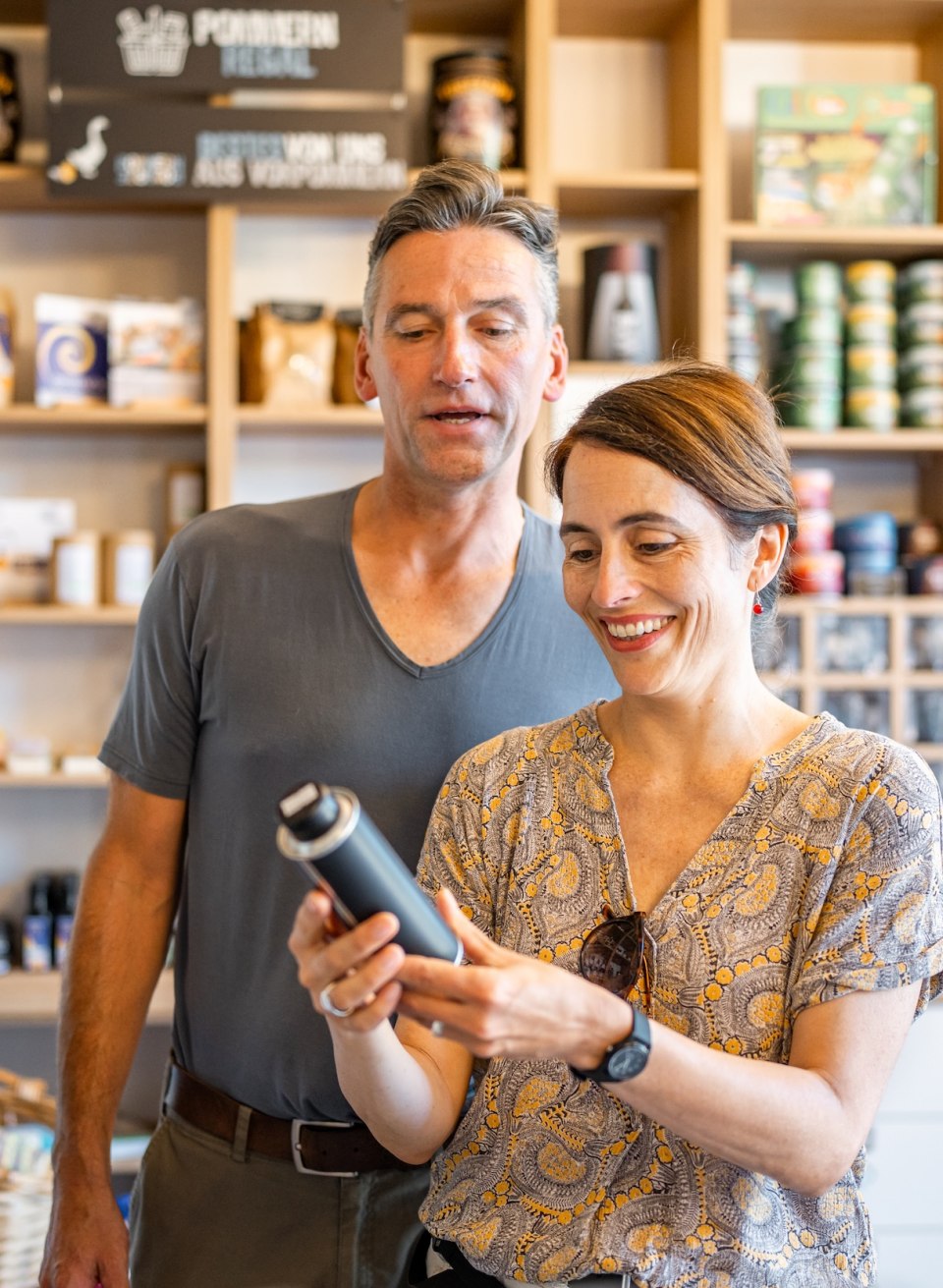 A couple looks at products in the farm store at Liepen Estate, surrounded by shelves of regional specialties.