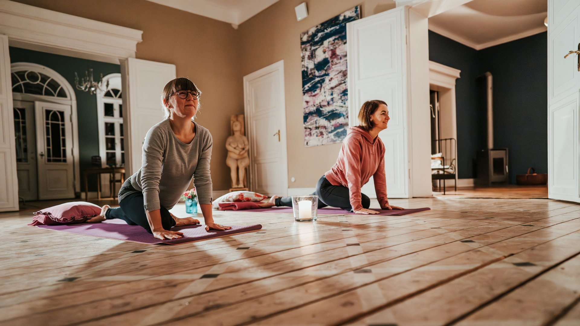 Two participants enjoy a yoga session at Gutshaus Pohnstorf - mindfulness and movement in stylish and relaxed surroundings.