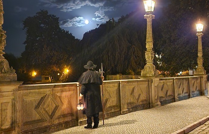 Night watchman on the bridge looking towards the castle at night., © Michael Kratt